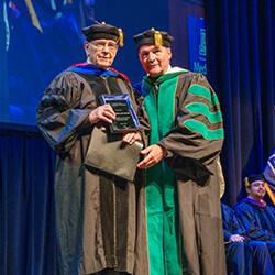 Dean Wondisford presents Dr. Watkins with the Stuart D. Flynn, MD, Master Educator Award Dean Wondisford presents Dr. Watkins with the Stuart D. Flynn, MD, Master Educator Award